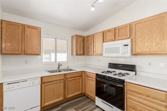 Kitchen with vaulted ceiling, light countertops, a sink, wood finished floors | Image 5