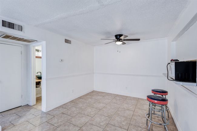 Empty room with visible vents, a textured ceiling, and ceiling fan | Image 9