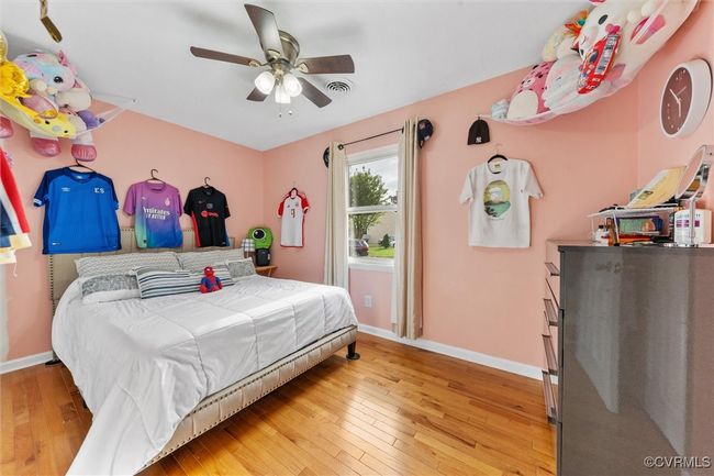 Bedroom with visible vents, baseboards, a ceiling fan, and wood-type flooring | Image 24