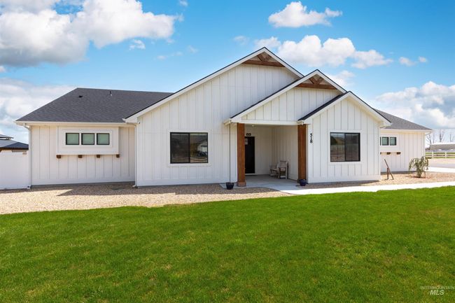 Back of house featuring board and batten siding, a lawn, and a shingled roof | Image 38