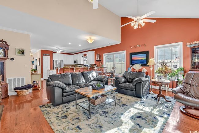 Living room featuring a high end fireplace, wood-type flooring, high vaulted ceiling, and ceiling fan | Image 16