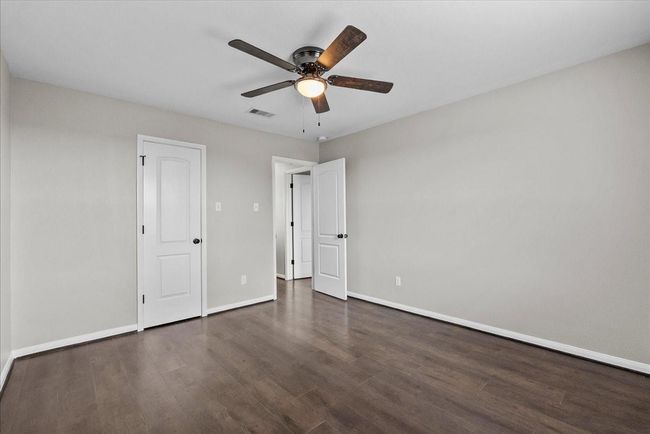 Bright and airy, this 3rd bedroom provides ample natural light and a welcoming atmosphere. | Image 24