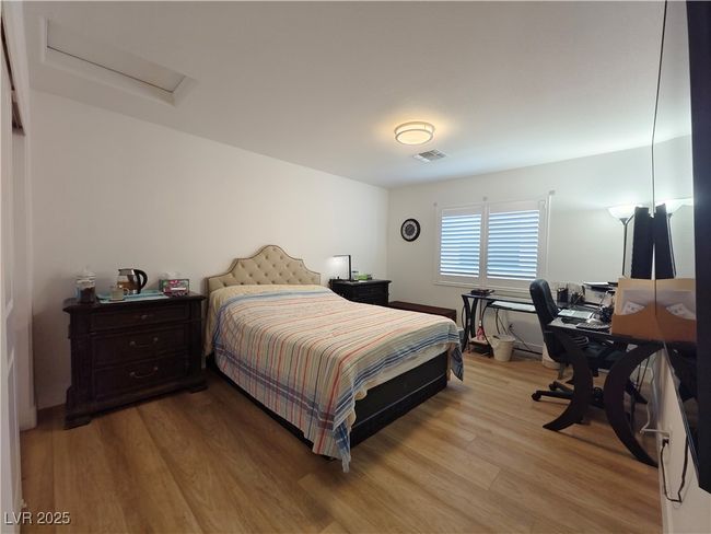 Bedroom with attic access, visible vents, and light wood finished floors | Image 27