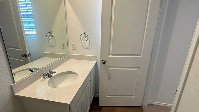 Half bathroom featuring a textured wall and vanity | Image 26