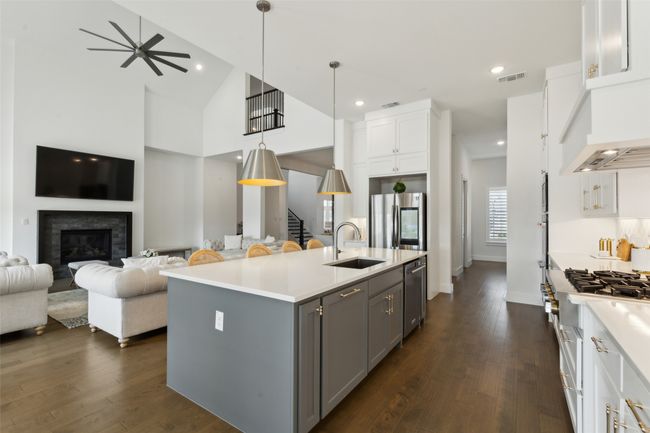 Kitchen with a sink, appliances with stainless steel finishes, open floor plan, gray cabinets, and light countertops | Image 11