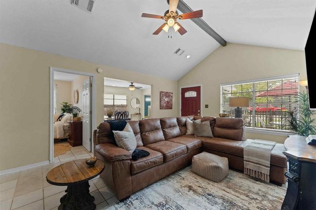 Cozy yet spacious living room featuring vaulted ceilings and a bold beam that adds character and charm to the heart of the home. | Image 4