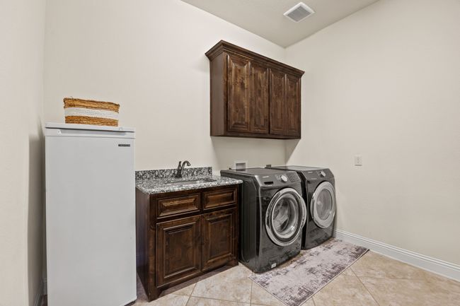 Spacious laundry room has a sink and space for a fridge | Image 35