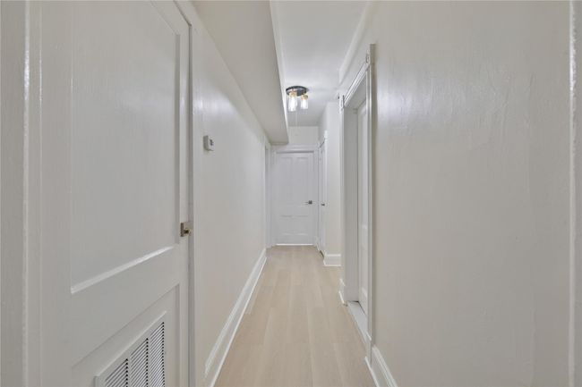 Hallway featuring baseboards and visible vents | Image 7