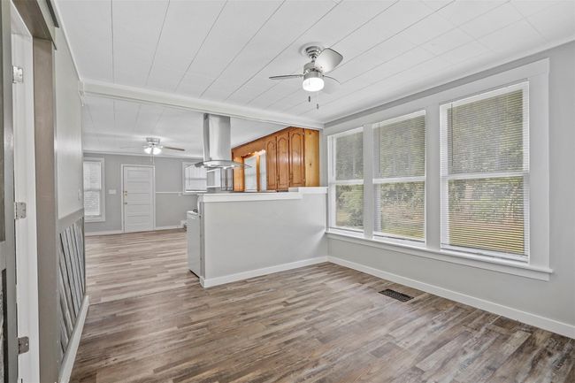 Kitchen featuring ceiling fan, island range hood, and wood finished floors | Image 4