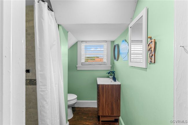 Full bath featuring a tile shower, toilet, baseboards, wood finished floors, and vanity | Image 20