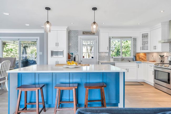 Kitchen featuring white cabinetry, stainless steel range with electric stovetop, light countertops, and decorative backsplash | Image 4