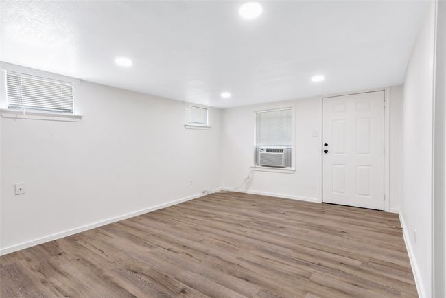 Below grade area featuring cooling unit, light wood finished floors, and recessed lighting | Image 30