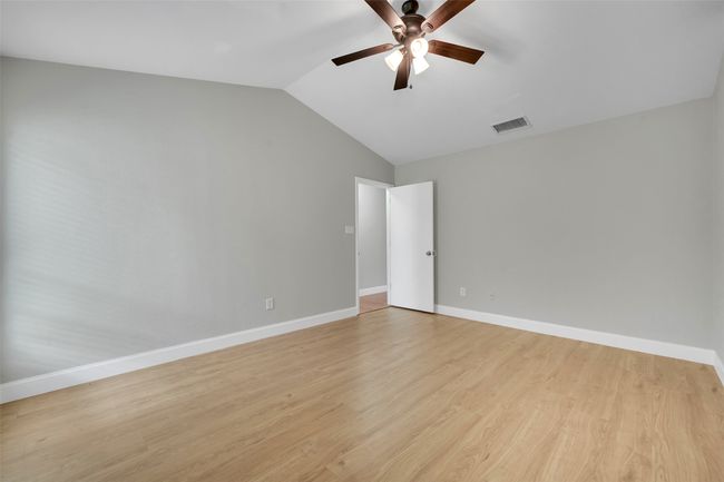 Empty room featuring vaulted ceiling, a ceiling fan, and light wood-type flooring | Image 14