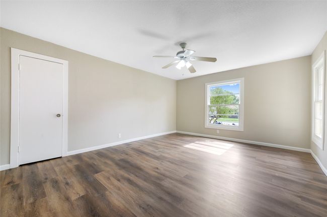 Unfurnished room with a ceiling fan and dark wood-style flooring | Image 24