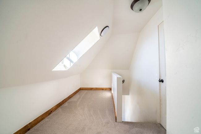 Bonus room featuring carpet floors, vaulted ceiling with skylight, and baseboards | Image 19