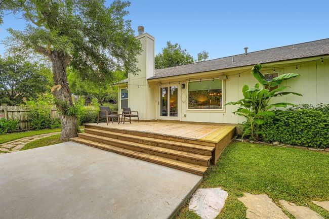 Back of house with a wooden deck, a patio, and a chimney | Image 26