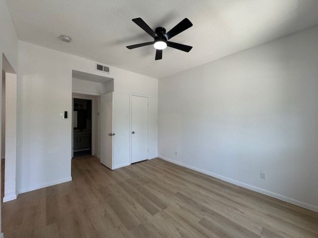 Unfurnished bedroom featuring wood finished floors, a ceiling fan, and a closet | Image 8