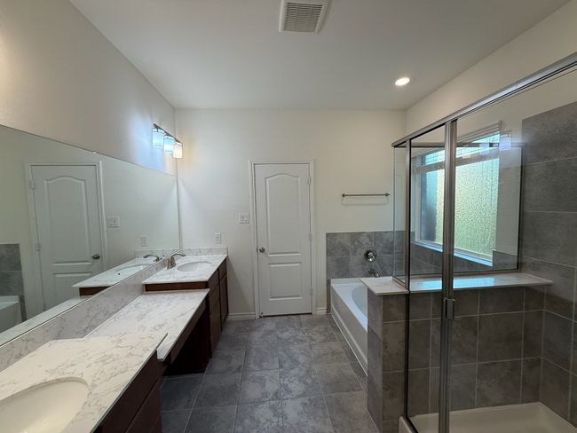 Bathroom featuring double vanity, a garden tub, and a stall shower | Image 15