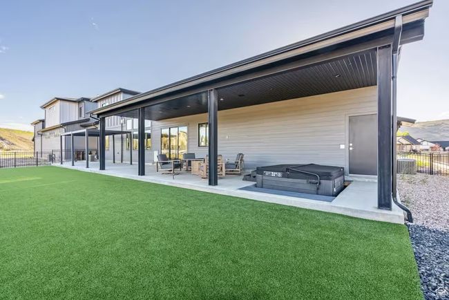 Back of house with a patio area, fence, a hot tub, and a lawn | Image 40