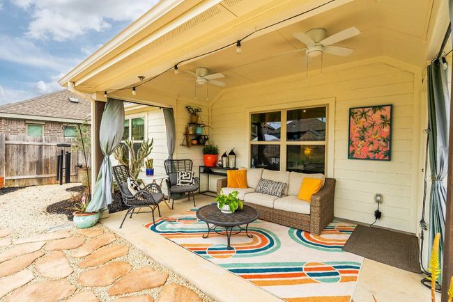 Back patio with a ceiling fan, fence, and an outdoor living space | Image 19