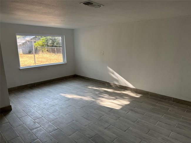 Empty room featuring a textured ceiling, wood tiled floor, visible vents, and baseboards | Image 32