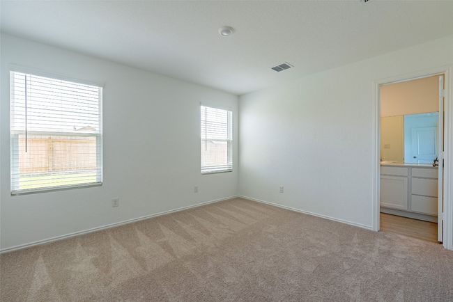 Unfurnished bedroom with light colored carpet, baseboards, and ensuite bathroom | Image 9