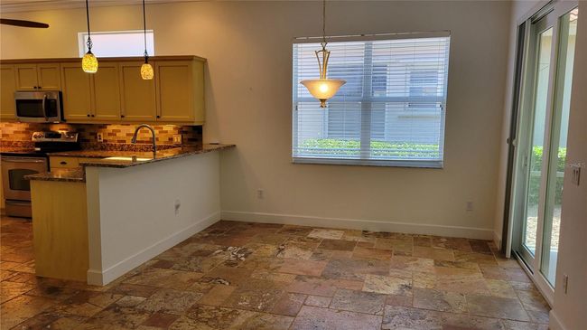 breakfast bar and eat in area of kitchen looking out on greenspace | Image 11