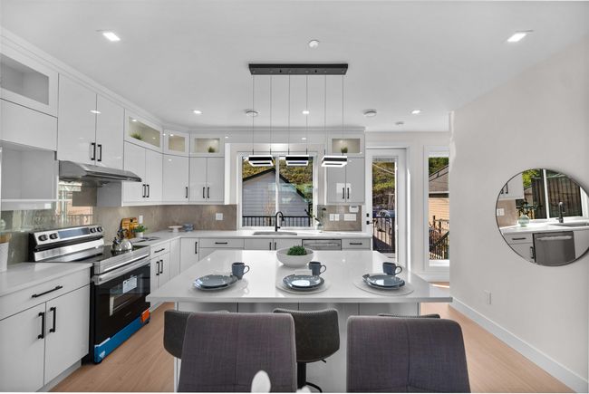 Kitchen featuring appliances with stainless steel finishes, under cabinet range hood, light wood-style flooring, light countertops, and backsplash | Image 9