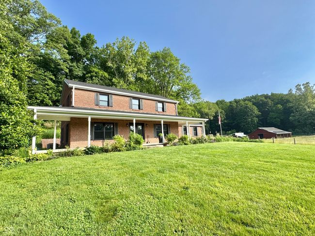 view of front of home featuring brick siding, a front lawn, and covered porch | Image 6