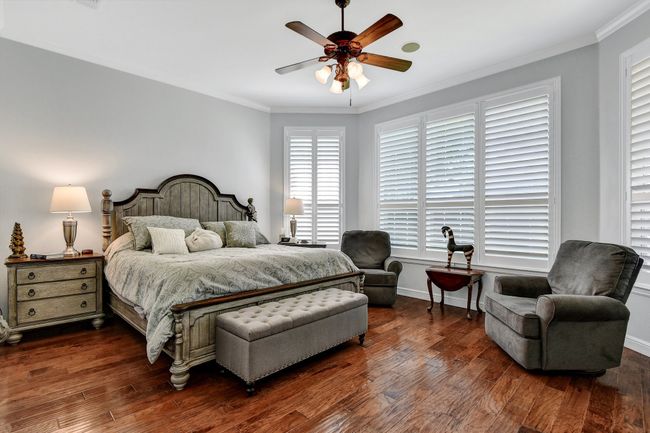 Bedroom with ornamental molding, dark wood-type flooring, and ceiling fan | Image 18