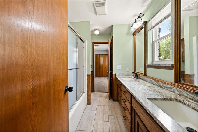Bathroom with double vanity and combined bath / shower with glass door | Image 27