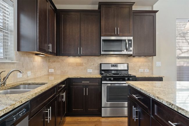 The gourmet kitchen offers high-end appliances and granite countertops. | Image 5