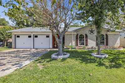 Ranch-style house featuring a front yard and a garage | Image 1