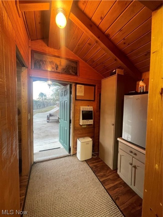 Kitchen with dark hardwood / wood-style flooring, wooden ceiling, vaulted ceiling, and wood walls | Image 36