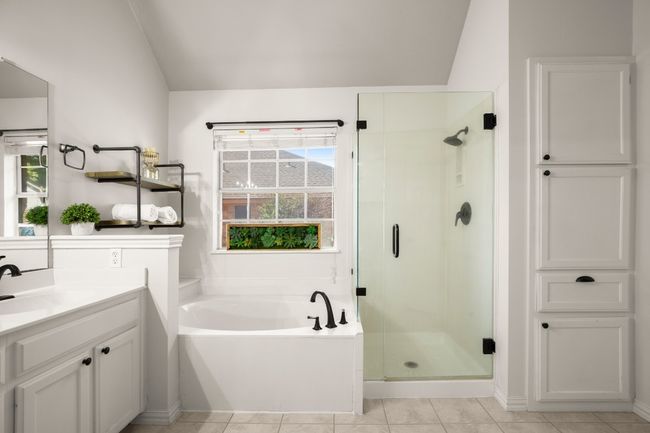 Bathroom featuring a stall shower, a garden tub, light tile patterned flooring, vanity, and vaulted ceiling | Image 20