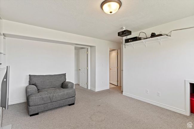 Living area with carpet, a textured ceiling, and baseboards | Image 22