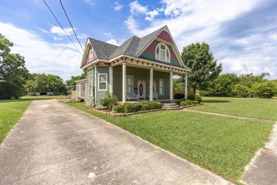 Victorian-style house with a front lawn and covered porch | Image 3