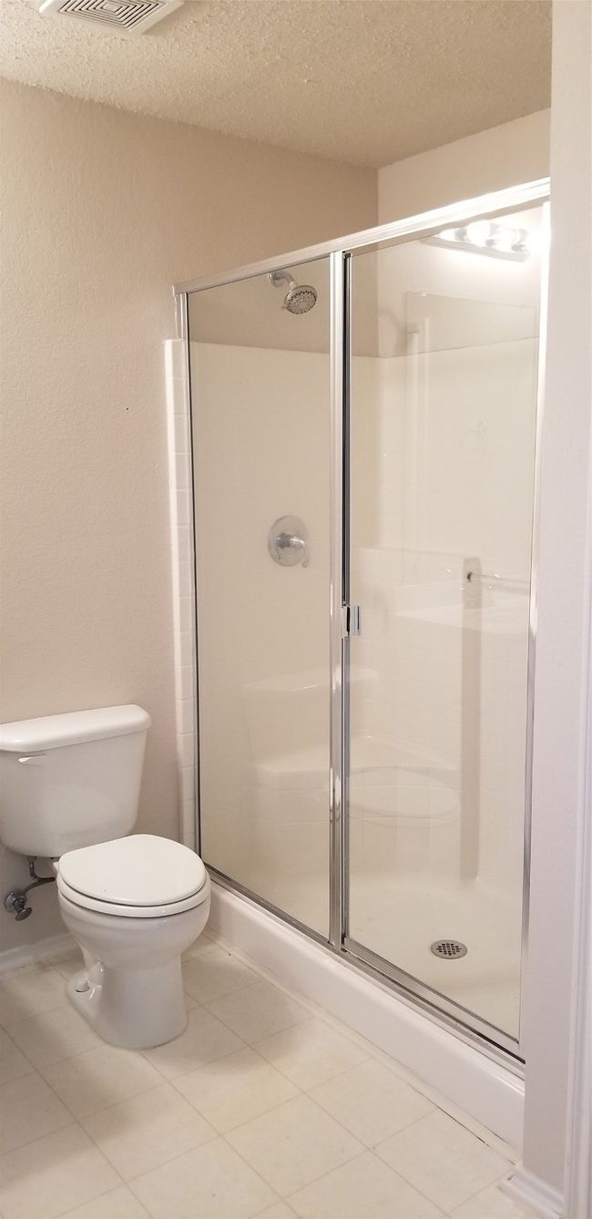 Bathroom featuring a shower stall, tile patterned flooring, and a textured ceiling | Image 15