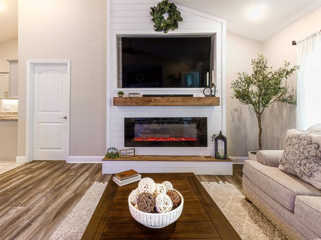 Living room featuring a large fireplace, vaulted ceiling, and hardwood / wood-style flooring | Image 5