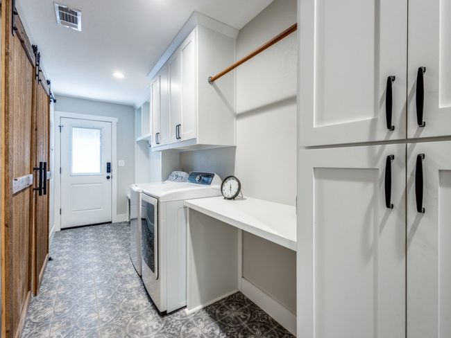 Mudroom area at the side door, laundry center with extensive storage, countertop for folding laundry, rod for hanging up clothes right out of the dryer, under counter storage for laundry baskets. Cedar barn doors to your left lead into the second living area. | Image 27