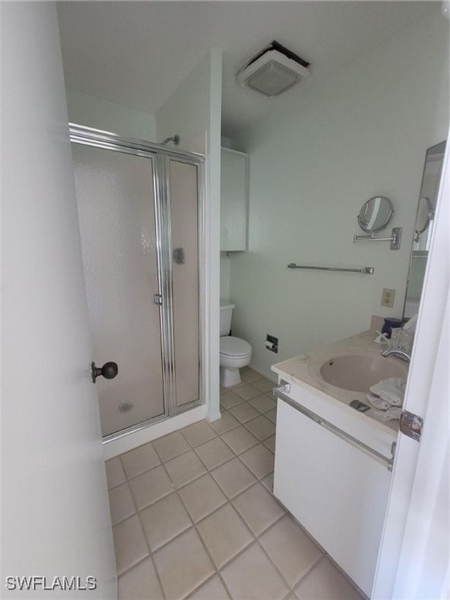 Bathroom featuring vanity, tile patterned flooring, a shower stall, and toilet | Image 19