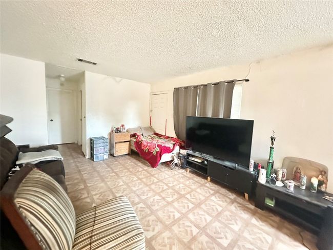 Living room featuring a textured ceiling and light flooring | Image 8