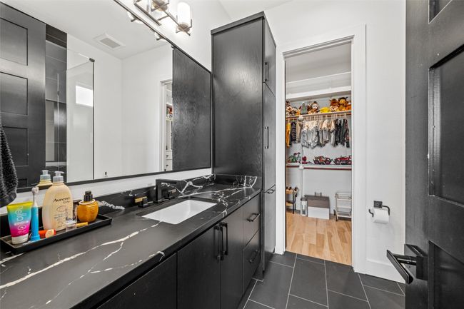 Bathroom with tile patterned floors, visible vents, vanity, and a walk in closet | Image 32