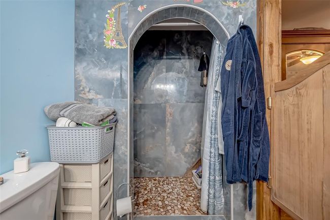 A graceful archway leads to a tiled shower alcove, adding unexpected elegance and a sense of refinement. | Image 25