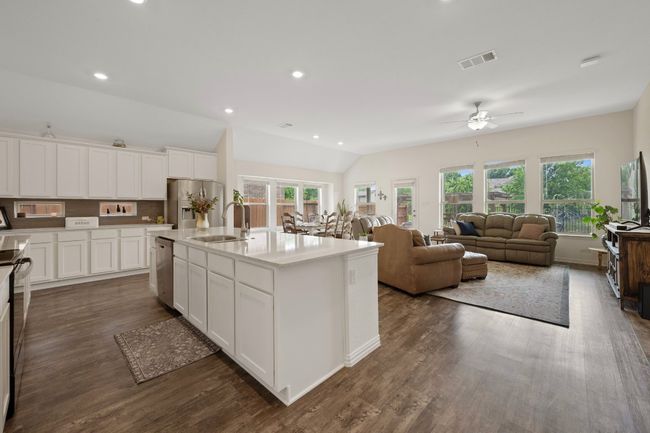 Kitchen with stainless steel appliances, a sink, ceiling fan, plenty of natural light, and lofted ceiling | Image 4