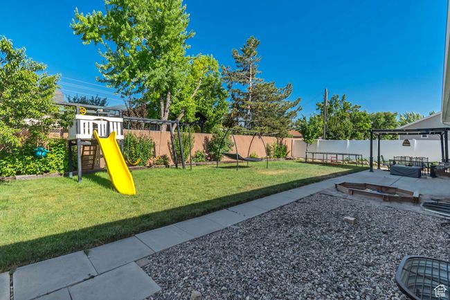 Fenced backyard with a playground and a patio | Image 32