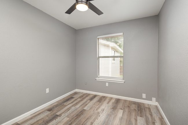 Empty room with light wood-style flooring, a ceiling fan, and baseboards | Image 33