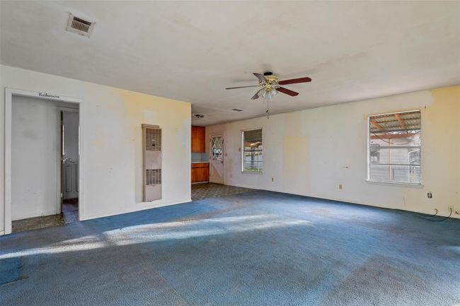 Unfurnished living room with a ceiling fan, a heating unit, and carpet floors | Image 10