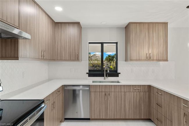 Kitchen featuring range, dishwashing machine, range hood, decorative backsplash, and sink | Image 19