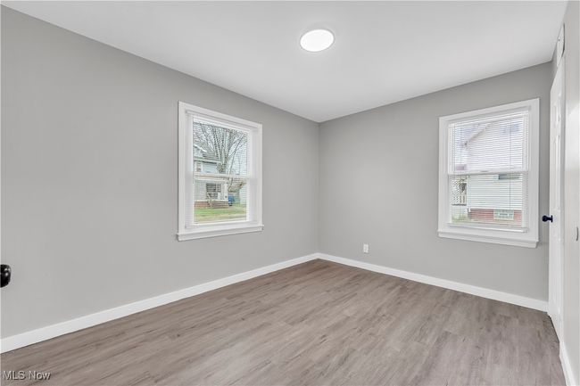 Spare room with baseboards and wood finished floors | Image 13